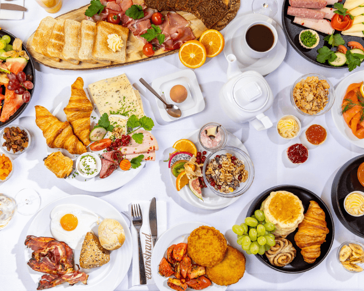 Leckeres Frühstück mit gesundem Obst, Brötchen, Croissant, Kaffee und vieles mehr